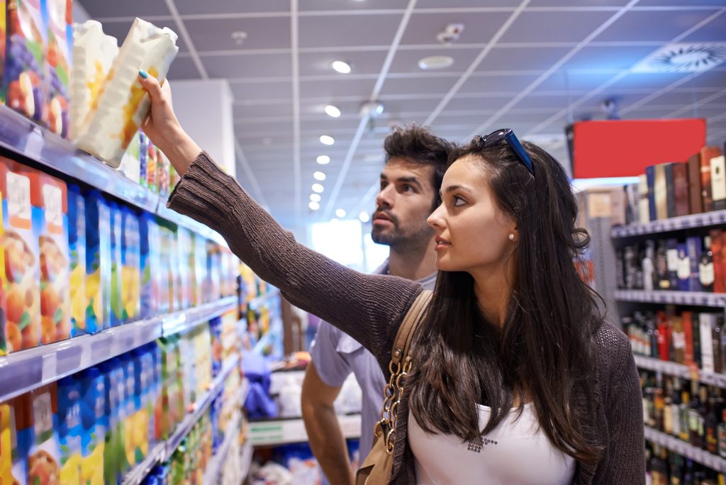 Parents reading food labels in an Australian supermarket aisle